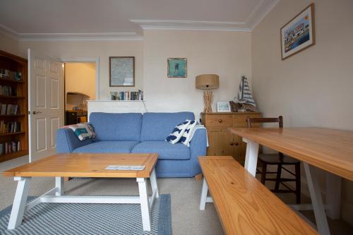 a living room with a blue couch and a table at Elegant 2 bed in the heart of Falmouth - sleeps 4 in Falmouth