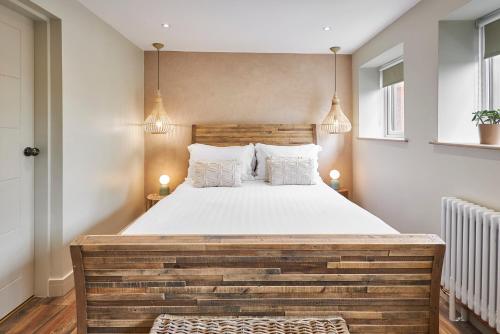 a bedroom with a large bed with a wooden headboard at The Believe Boutique (Believe Bar & Bedrooms) in Redcar