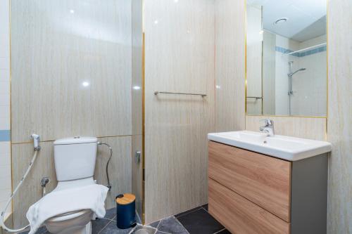 a bathroom with a toilet and a sink and a mirror at Tecom-Barsha Heights Retreat 2BR Stroll to Metro in Dubai