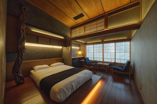 a bedroom with a bed and a desk and a window at Tudzura in Kumamoto