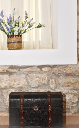 a black suitcase sitting on the floor with a vase of flowers at Captain Theo's modern apartment Maria in Lefkímmi