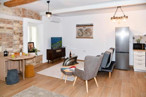 a living room with a table and chairs and a kitchen at Captain Theo's modern apartment Maria in Lefkímmi
