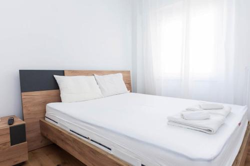 a bed with white sheets and white towels on it at Kallithea Modern Living with Designer Touch in Athens