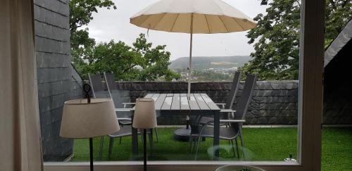 a table and chairs with an umbrella on a patio at Ferienapartment Linz am Rhein in Linz am Rhein