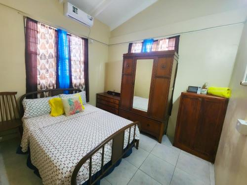 Schlafzimmer mit einem Bett, einer Kommode und einem Spiegel in der Unterkunft La Kaye Nou by SMO Wellness in Soufrière