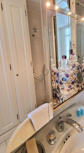 La salle de bains est pourvue d'un lavabo et d'un miroir. dans l'établissement Christina : A deux pas de la Tour Eiffel, à Paris