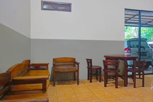 een kamer met houten stoelen en tafels en een raam bij Bright Batavia in Jakarta