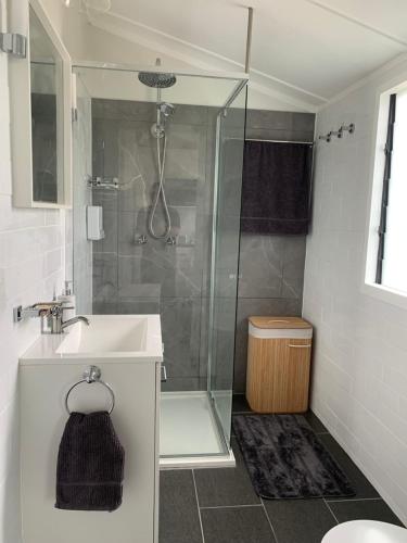 ein Bad mit einer Dusche und einem Waschbecken in der Unterkunft West End Studio 2 in Brisbane