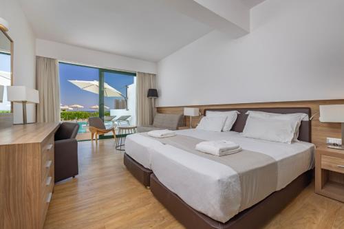 a bedroom with a large bed and a living room at Calypso Palace in Faliraki