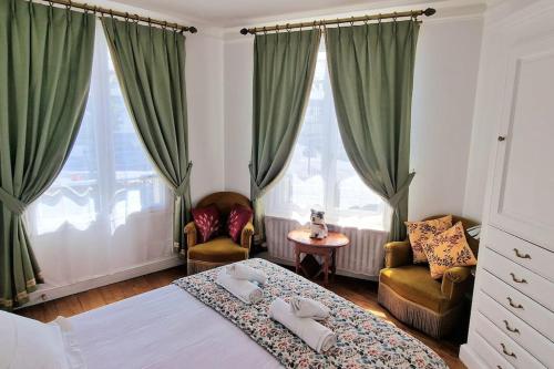 une chambre avec un lit et deux chaises dans l'établissement Christina : A deux pas de la Tour Eiffel, à Paris