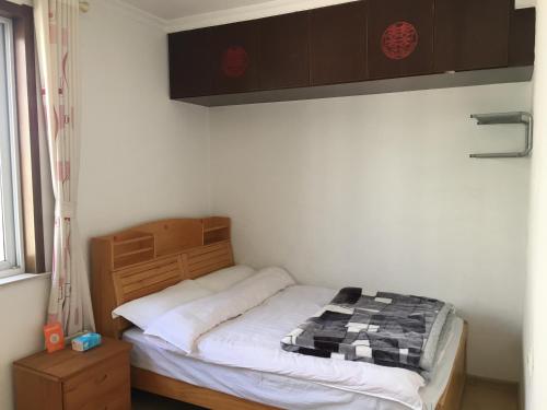 a small bedroom with a bed in a room at 雅伦之屋 Yailon Aparment in Nanjing