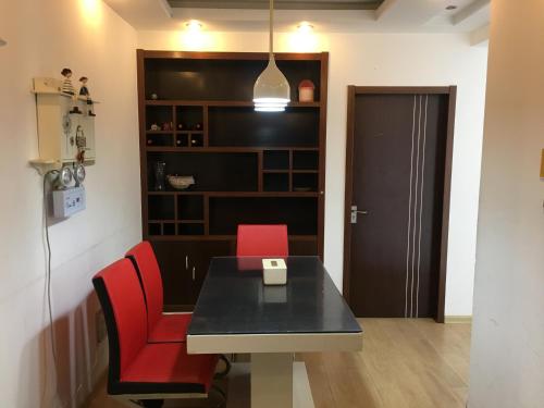 a dining room with a table and two red chairs at 雅伦之屋 Yailon Aparment in Nanjing