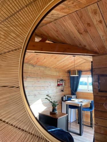 - un miroir rond dans une chambre avec une table dans l'établissement La Cabane dans les Arbres - Les Pieds dans le Pré, à Les Landes-Génusson