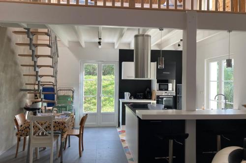 une cuisine et une salle à manger avec une table et des chaises dans l'établissement Comfortable and nice house with a beautiful garden, à La Tranche-sur-Mer