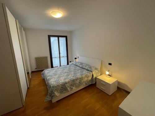 a bedroom with a bed and a table and a window at Trilocale vista mare con 2 bagni nel centro storico - Agenzia Cocal in Caorle