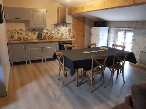 une cuisine avec une table et des chaises dans une pièce dans l'établissement Le gîte Joyeuse triplette Limoux Carcassonne, à Limoux