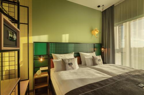 a bedroom with a large bed with white sheets and pillows at the niu Dwarf in Berlin