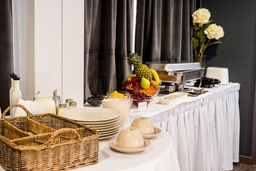 a white table with plates and fruit on it at Elina Hotel Apartments in Rethymno Town
