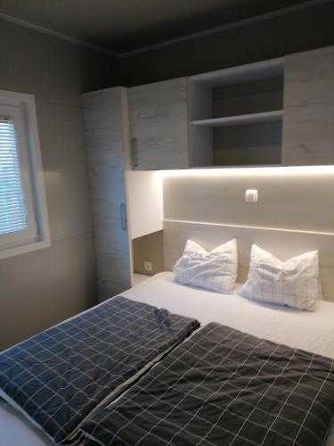 a bedroom with a large bed with two pillows at GF Mobilehomes Kroatien in Drage