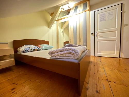 a bedroom with a bed with a wooden floor at Schöpfwerk Hostel 10 in Vienna