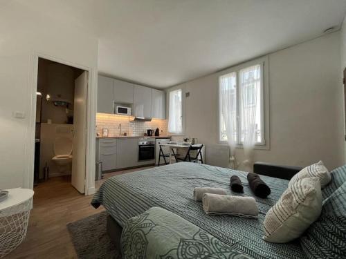 une chambre avec un grand lit et une cuisine dans l'établissement Le Studio Noir et Blanc, à Fontainebleau