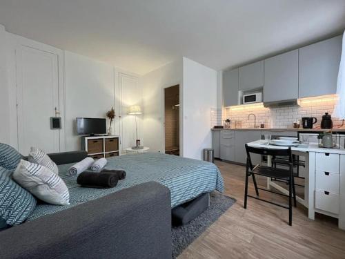 une chambre avec un lit et une cuisine avec une table dans l'établissement Le Studio Noir et Blanc, à Fontainebleau