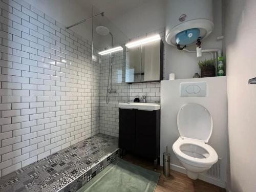 une salle de bain blanche avec des toilettes et un lavabo dans l'établissement Le Studio Noir et Blanc, à Fontainebleau