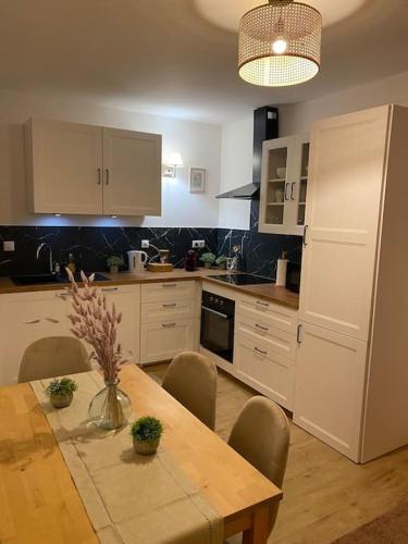 une cuisine avec une table en bois et des chaises ainsi qu'une salle à manger dans l'établissement Charmant T3 à côté des Thermes, à Luxeuil-les-Bains