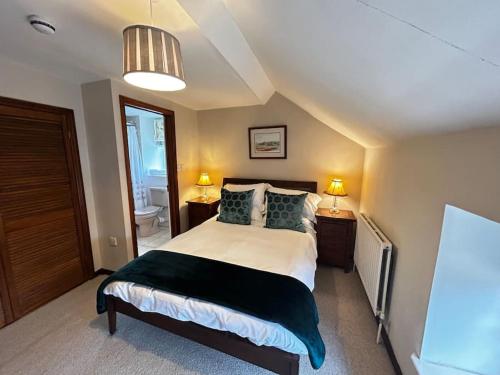 a bedroom with a large bed with two lamps at Robin in Lyddington