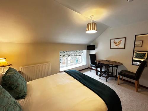 a bedroom with a bed and a table in it at Robin in Lyddington