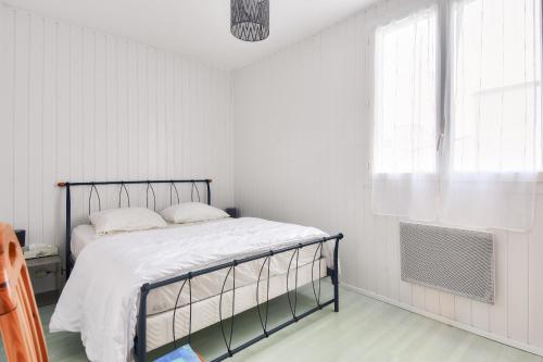 une chambre avec un lit et une fenêtre dans l'établissement Douce échappée à deux pas de la plage, à Saint-Hilaire-de-Riez