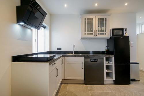 a kitchen with a black refrigerator and a sink at Beachstudio - Centrum Callantsoog aan Zee in Callantsoog