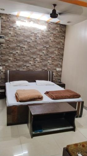 duas camas num quarto com uma parede de tijolos em Hotel plaza em Rohtak
