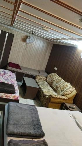 um quarto com três camas e uma mesa em Hotel plaza em Rohtak