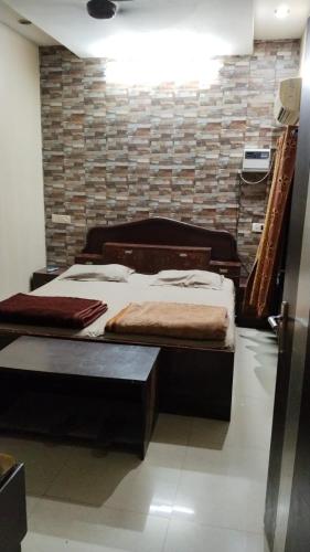 Hotel plaza في Rohtak: سريرين في غرفة مع جدار من الطوب