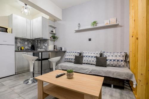 - un salon avec un canapé et une table dans l'établissement CityScape Studio, à Alexandroúpolis