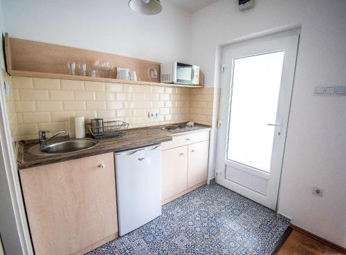 una piccola cucina con lavandino e porta di Zier Apartman a Balatonszemes