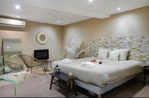 a bedroom with a large bed with a stone wall at L'escapade in Auriol