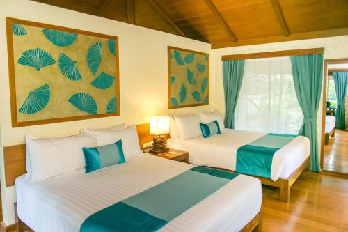 two beds in a hotel room with blue and white at Centara Koh Chang Tropicana Resort in Ko Chang