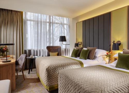 a hotel room with two beds and a desk at Mespil Hotel in Dublin