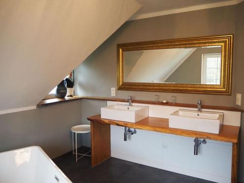 a bathroom with two sinks and a mirror at Wohlfühlhaus, hell und modern in Wardenburg