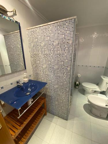 y baño con lavabo azul y aseo. en Apartamento en Gijon, en Gijón