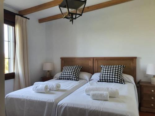2 bedden in een slaapkamer met witte lakens en kussens bij CASA RURAL MONTE DE AJUDA in Olivenza