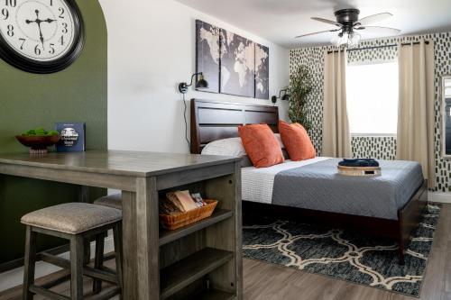 a bedroom with a bed with a desk and a clock at Step Free Entrance-Wolfe Cottage at Wrenwood Ranch, King Bed in Johnson City