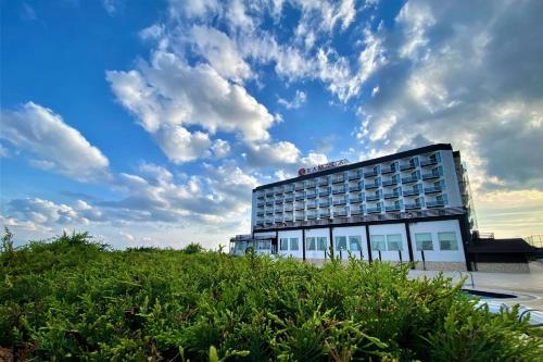 テキルダーにあるRamada by Wyndham Tekirdağの曇天を背景にしたホテルの建物
