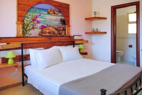 a bedroom with a bed and a painting on the wall at Tenuta Primaterra in Melendugno