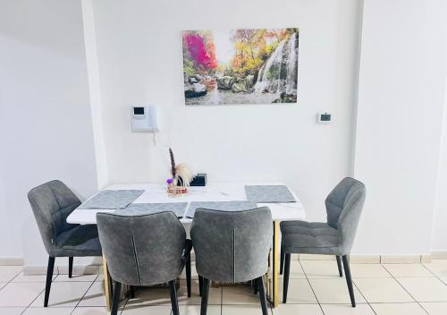a dining room table with chairs and a painting on the wall at STA Homes Dubai in Dubai