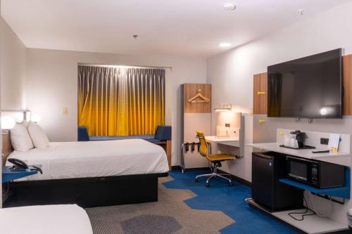 Habitación de hotel con cama y escritorio con ordenador en Microtel Inn & Suites by Wyndham Pigeon Forge, en Pigeon Forge