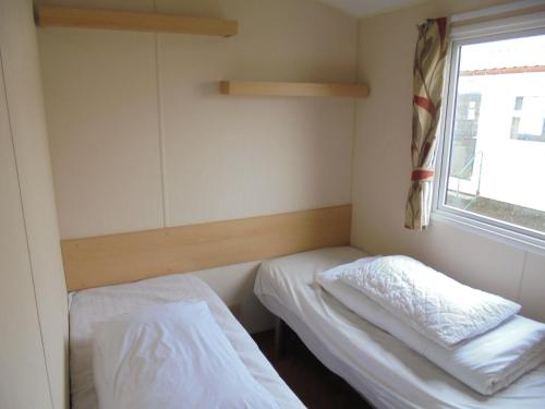 a small room with two beds and a window at 8 Berth on Coastfields Ingoldmells (Vacation) in Ingoldmells