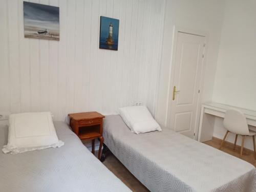 サン・フェリウ・デ・ギホルスにあるLa vinyaのベッド2台、テーブル、ドアが備わる客室です。